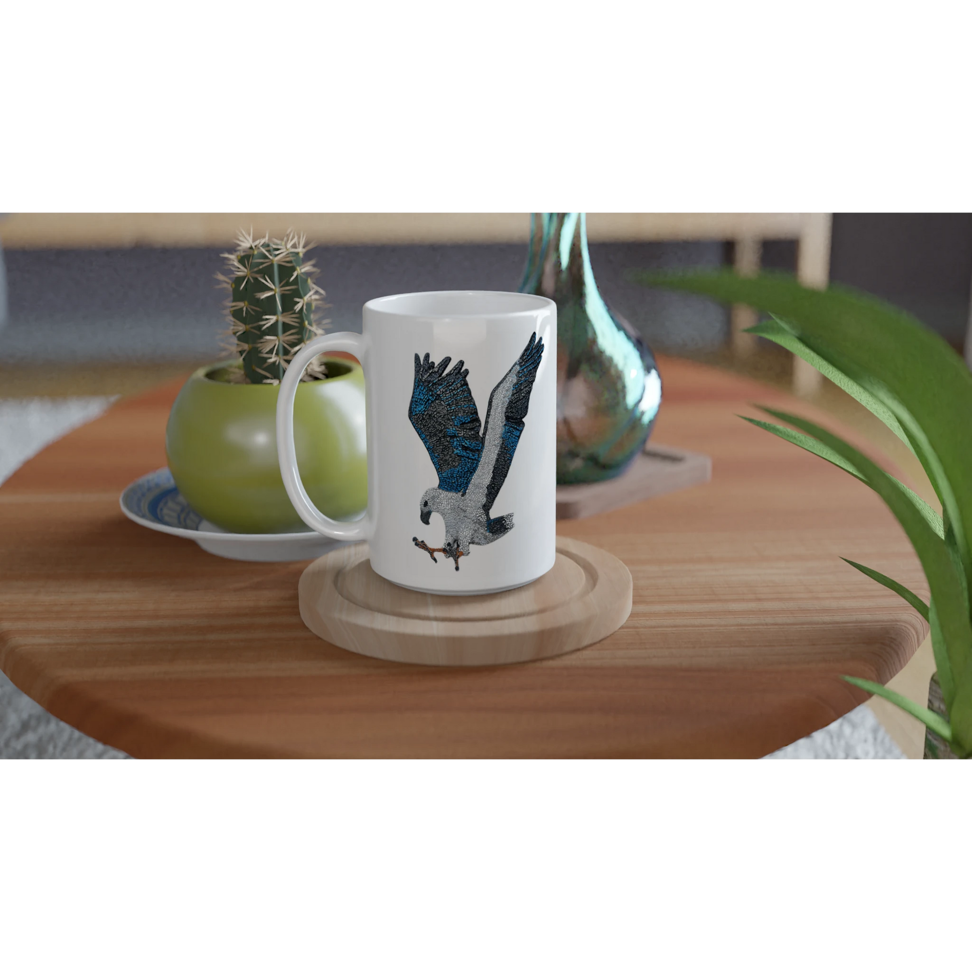willow the white-bellied sea eagle mosaic design printed on white 15oz ceramic mug set up in a lifestyle setting on a coffee table on a coaster with vases and a cactus