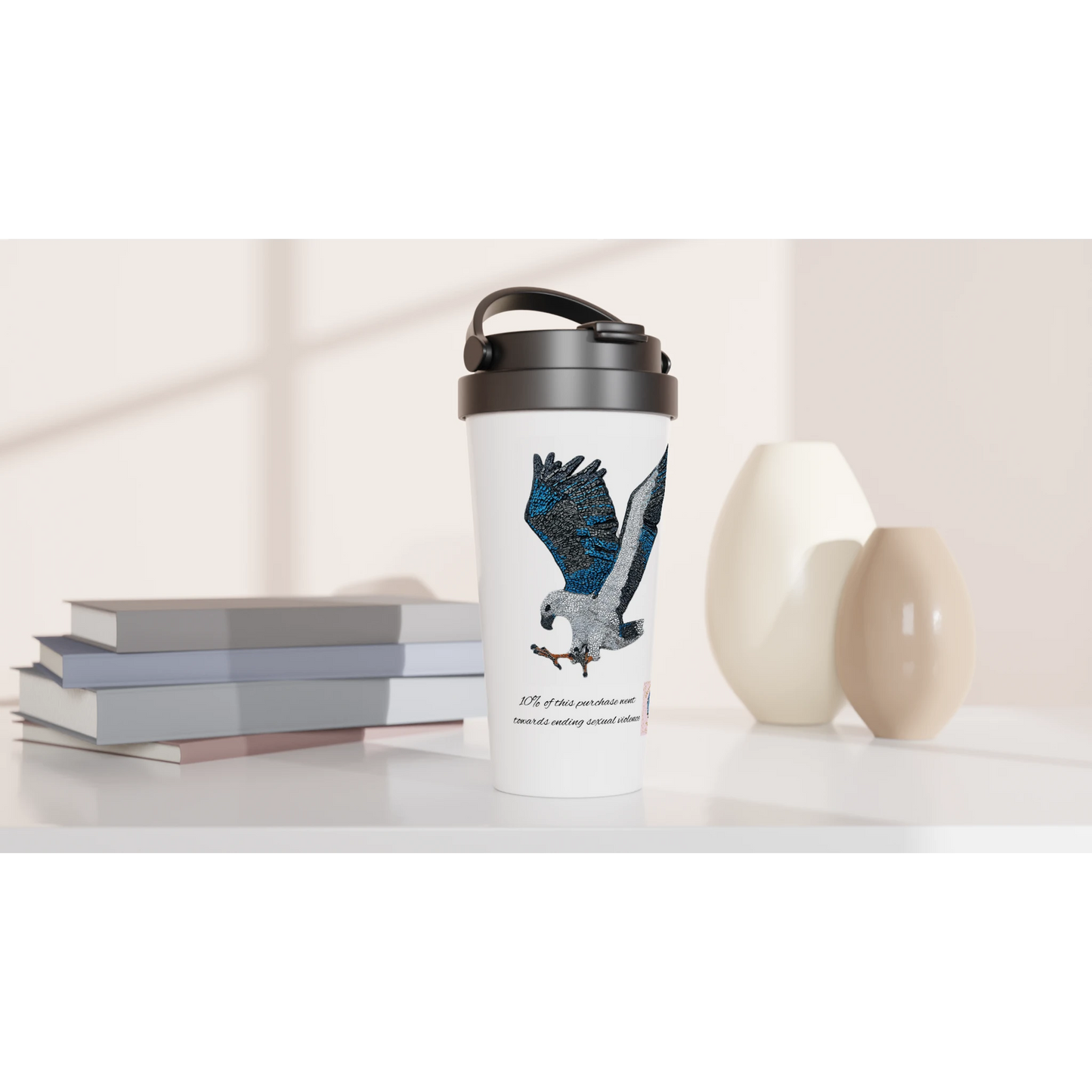 Willow the white-bellied sea eagle mosaic travel mug displayed on a table with books and vases