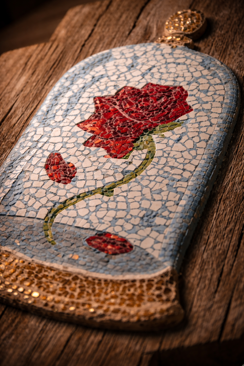 Mosaic art piece with red cursed rose design on a textured surface close up deatil shot