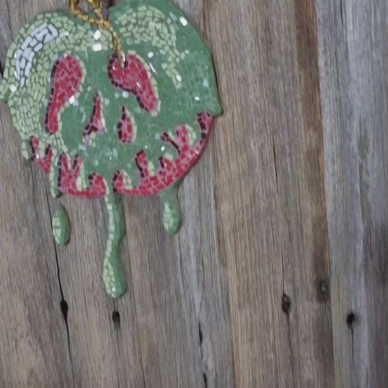"Short video capturing the light sparkling across the surface of the completed Poisoned Apple mosaic. The reflective glass tiles shimmer as the mosaic shifts in the light, revealing rich reds and dark, enchanted tones."