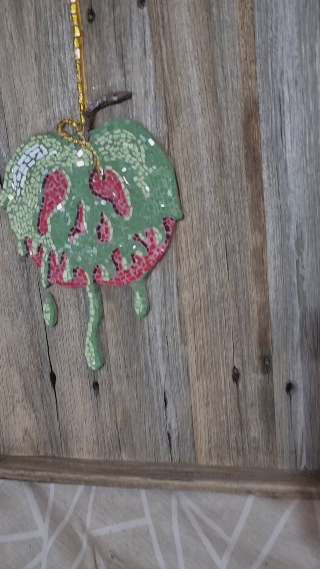 "Short video capturing the light sparkling across the surface of the completed Poisoned Apple mosaic. The reflective glass tiles shimmer as the mosaic shifts in the light, revealing rich reds and dark, enchanted tones."