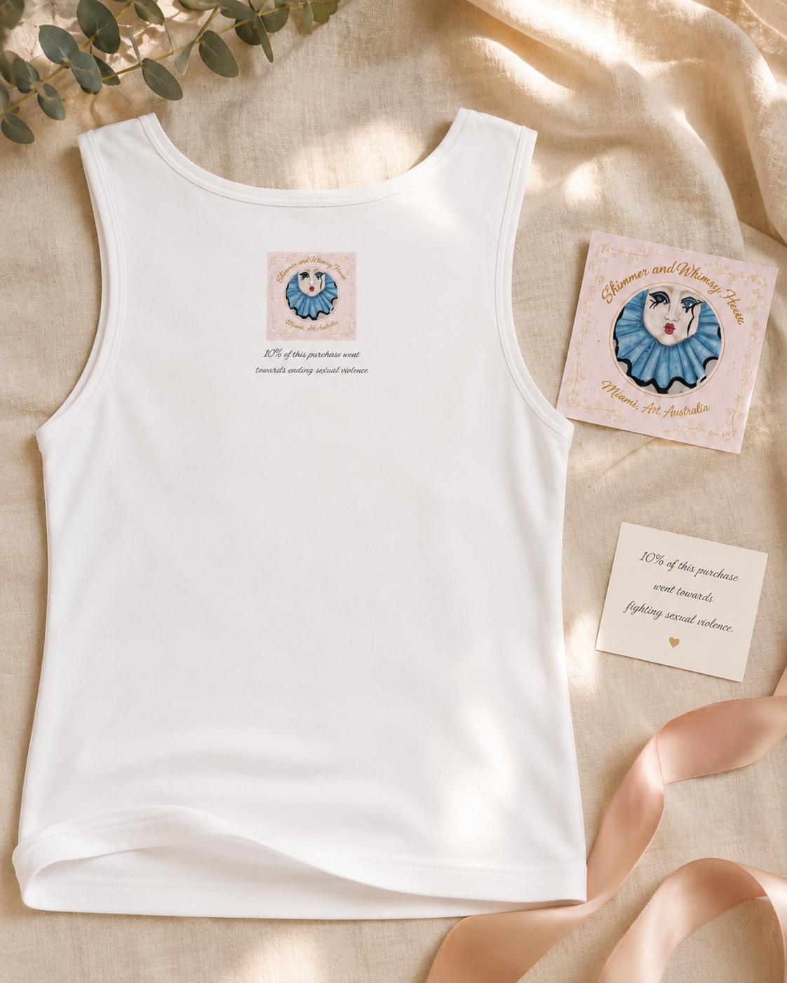 Close-up of the back of the Willow tank top showing the discreet Shimmer & Whimsy House artwork logo and giving message about 10% of the purchase supporting the fight against sexual violence, highlighting the ethical purpose behind this artist-designed garment.