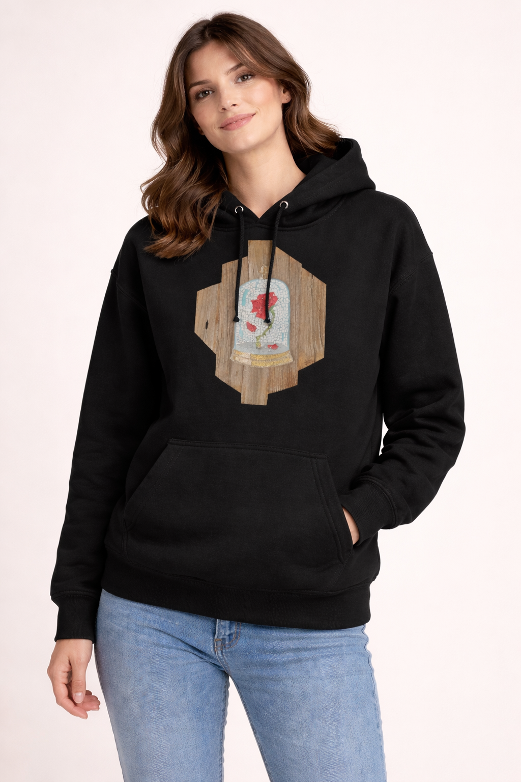 Woman wearing a black hoodie with a wooden design and red flower on a light pink background. the cursed rose mosaic design