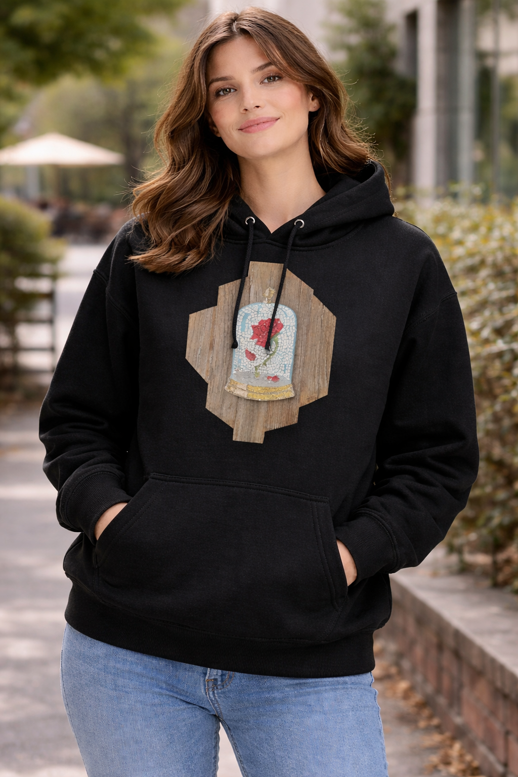 Woman wearing a black hoodie with a wooden the cursed rose mosaic design outdoors lifestyle shot