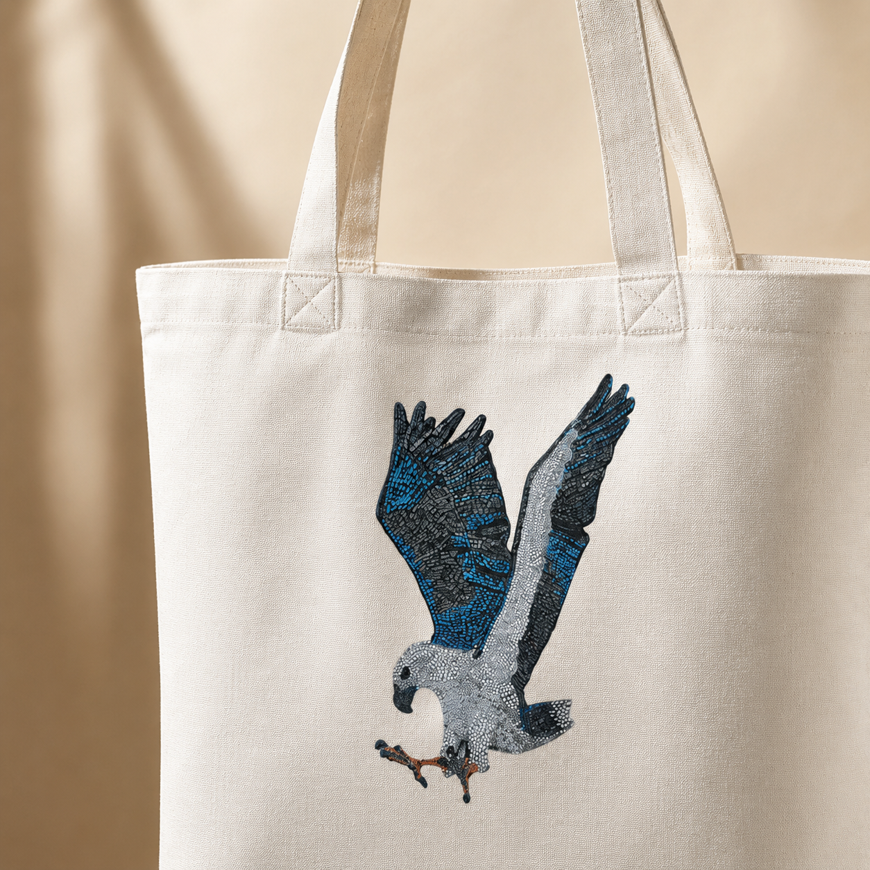 Close-up detail of the Willow cotton tote bag showing reinforced handles, stitching, woven cotton texture, and the printed White-bellied Sea Eagle mosaic artwork, photographed with soft side lighting to highlight the quality, fabric detail, and crisp wildlife design.
