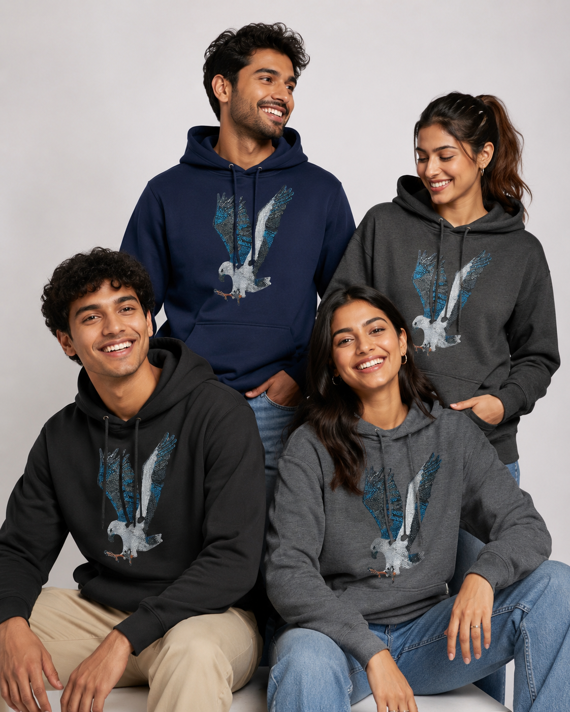 Group of male and female models wearing Willow White-bellied Sea Eagle mosaic hoodies in different colours, showing the unisex fit, relaxed styling, and detailed bird artwork on the front.